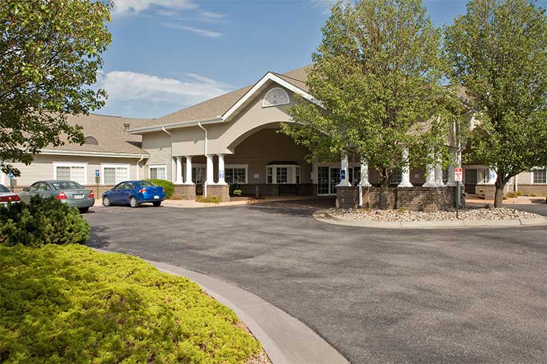 Front entrance of a senior living facility with landscaping