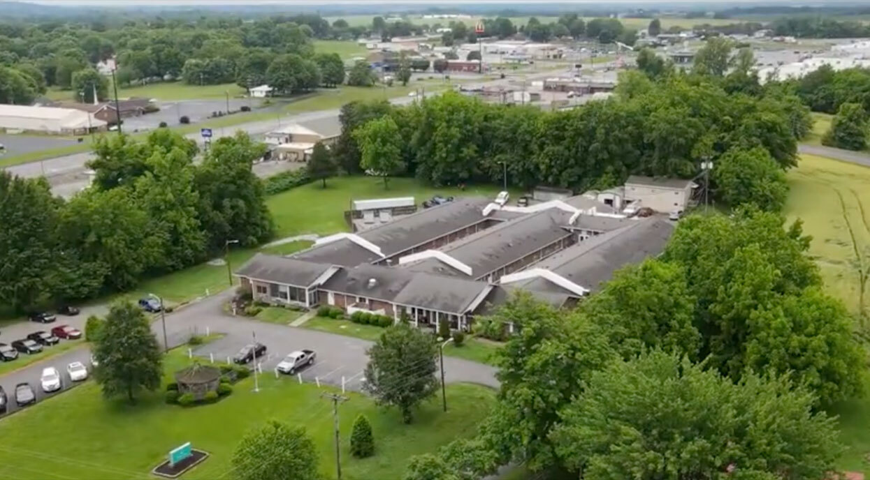 Aerial view of a senior living facility surrounded by greenery