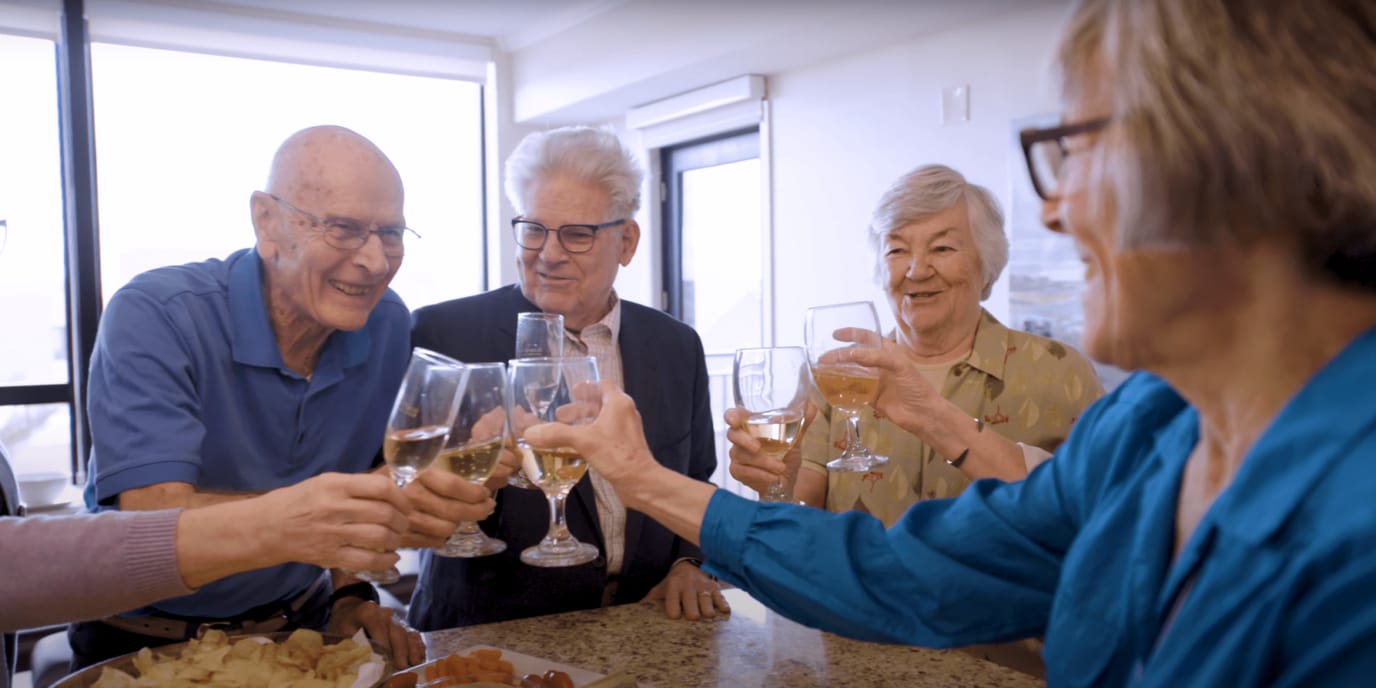 Residents toasting with glasses in a communal setting