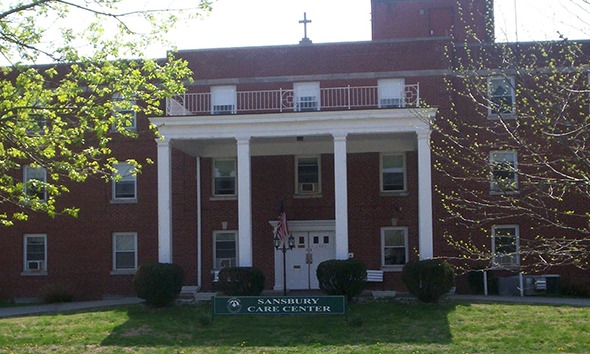 Front exterior of Sansbury Care Center with greenery