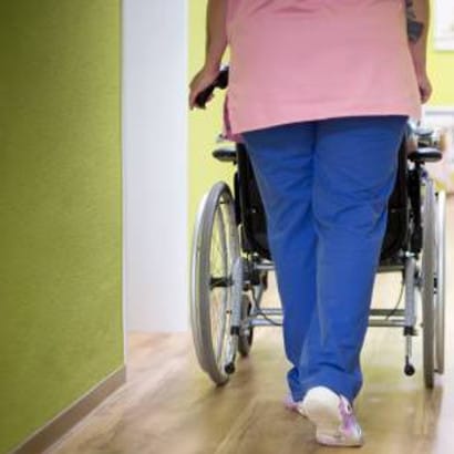 Courtyards Community Living Center, Nursing Home in Fulton, MS — Staff member guiding a resident in a wheelchair