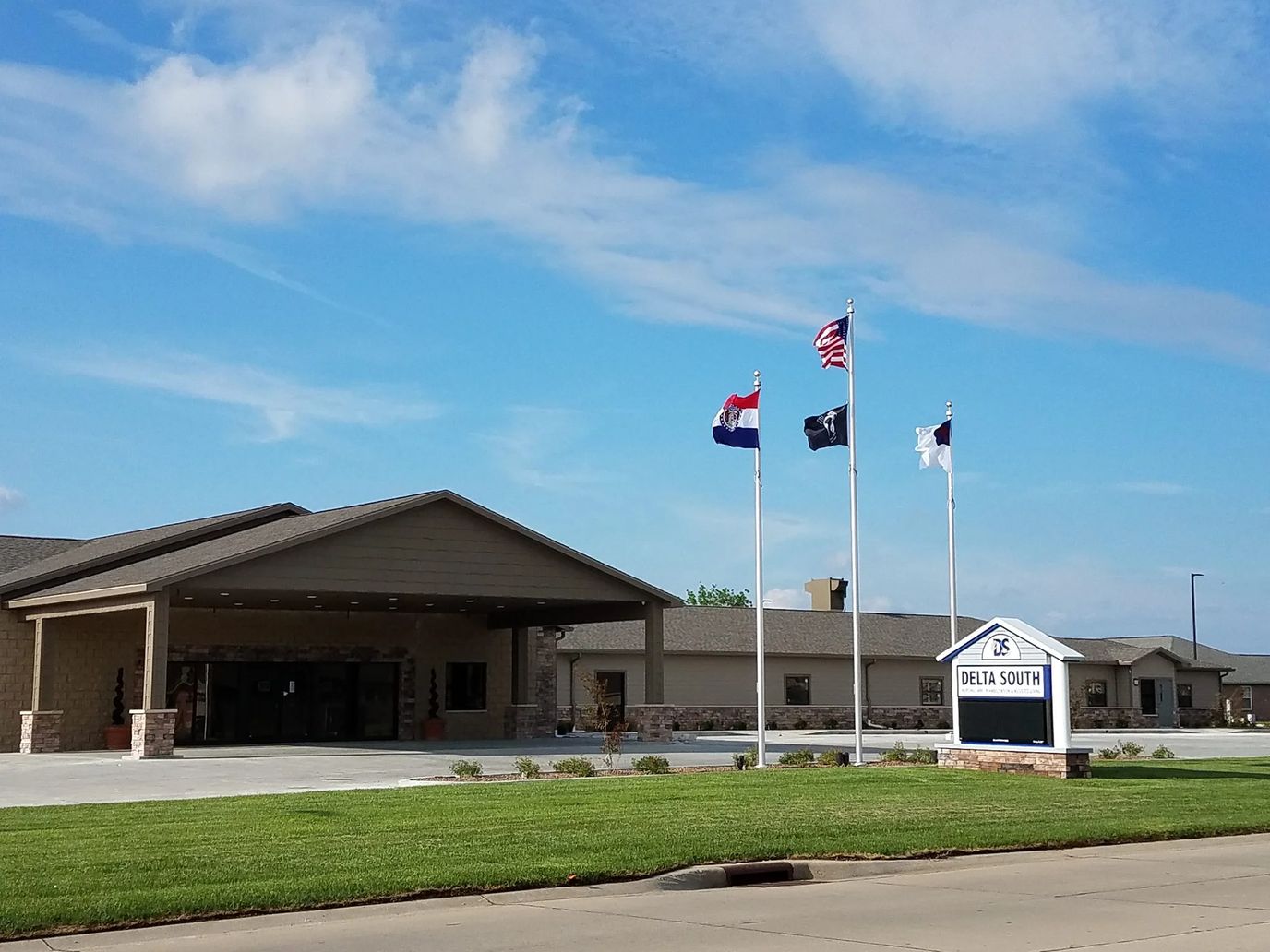 Exterior view of a senior living facility with flags