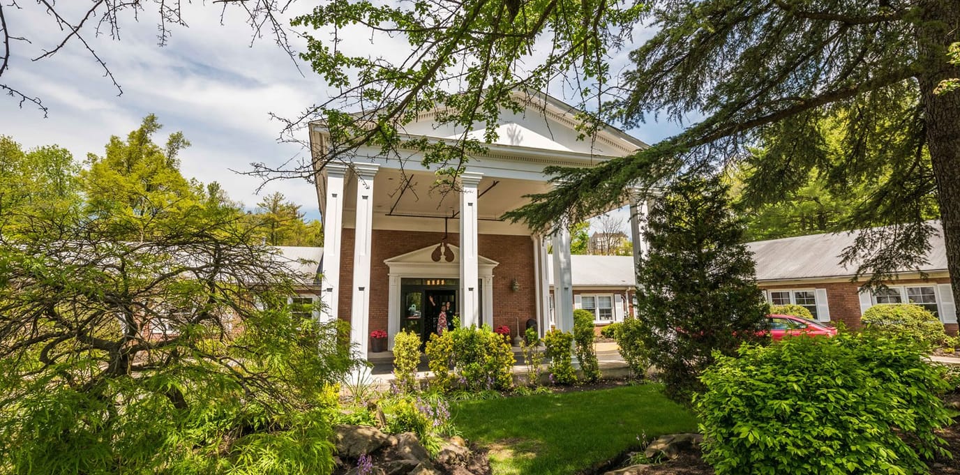 Entrance of a senior living facility with landscaped gardens