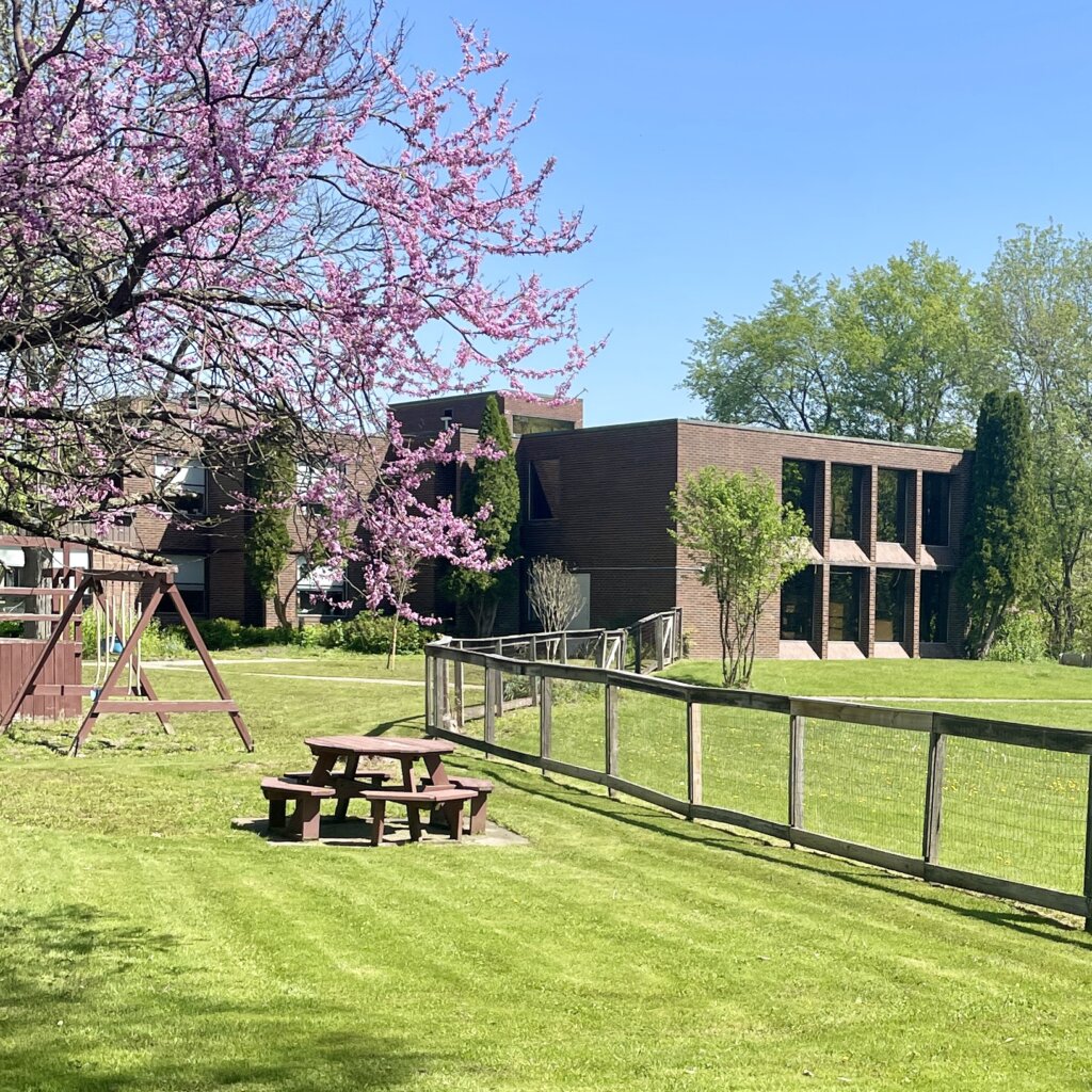 Exterior view of a building with outdoor seating and gardens