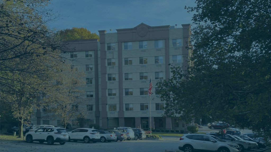 Exterior view of a senior living facility with parking area