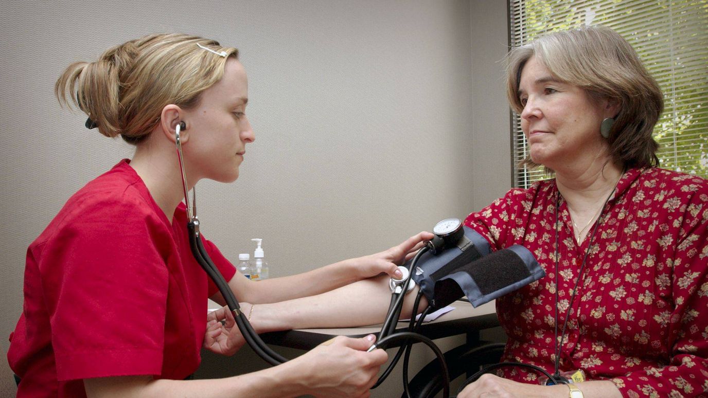 Nurse taking blood pressure of a resident in an office