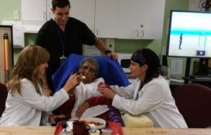 Brookhaven Rehabilitation & Health Care Center LLC, Nursing Home in Far Rockaway, NY — Staff assisting a resident during mealtime in a care center