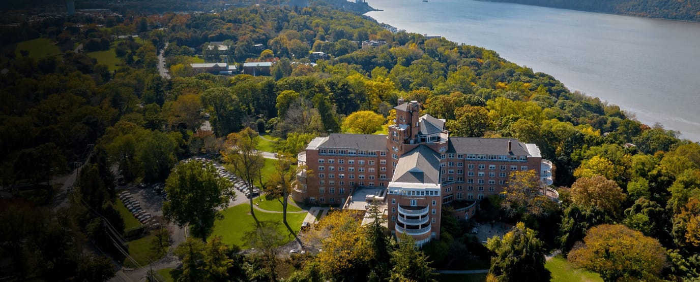 Aerial view of a large senior living facility by the river