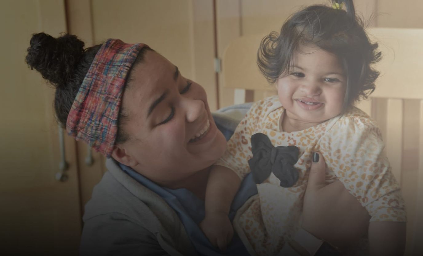 Caregiver happily holding a toddler