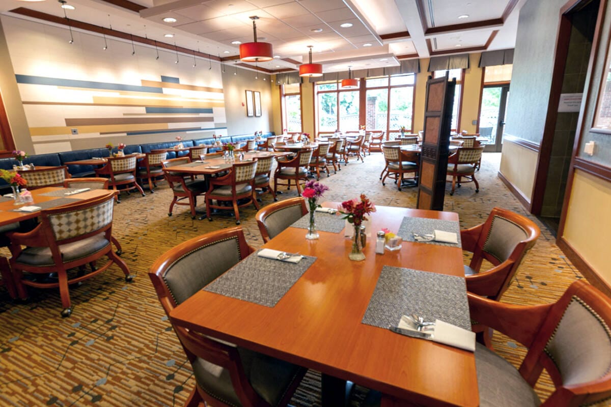 Bright dining room with wooden tables and floral centerpieces