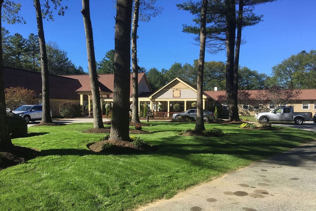 Exterior view of a senior living facility with landscaped front yard