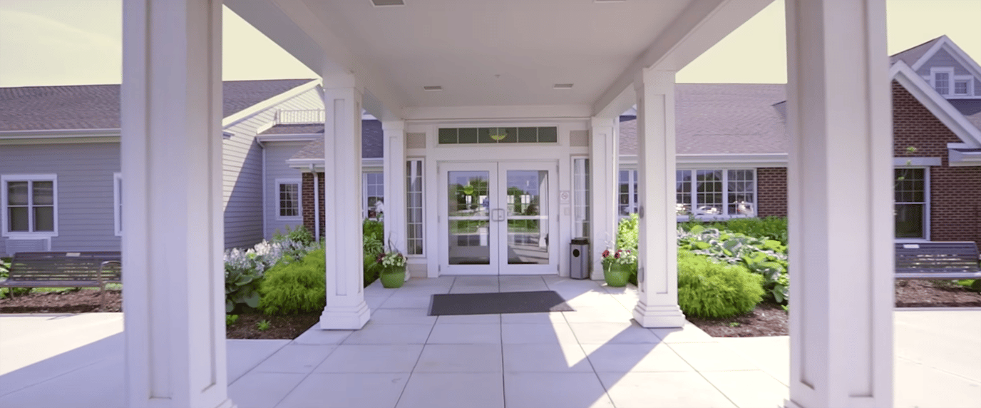 Entrance of a senior living facility with gardens