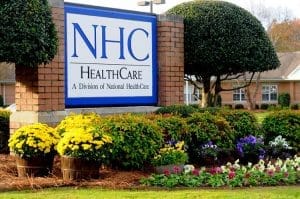 Nhc Healthcare Clinton, Nursing Home in Clinton, SC — Signage for NHC Healthcare surrounded by colorful flowers