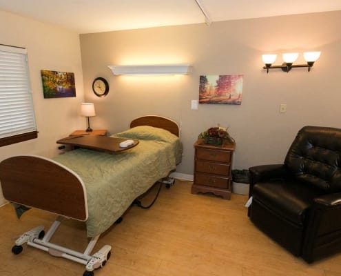 Cozy private resident room with a bed and armchair