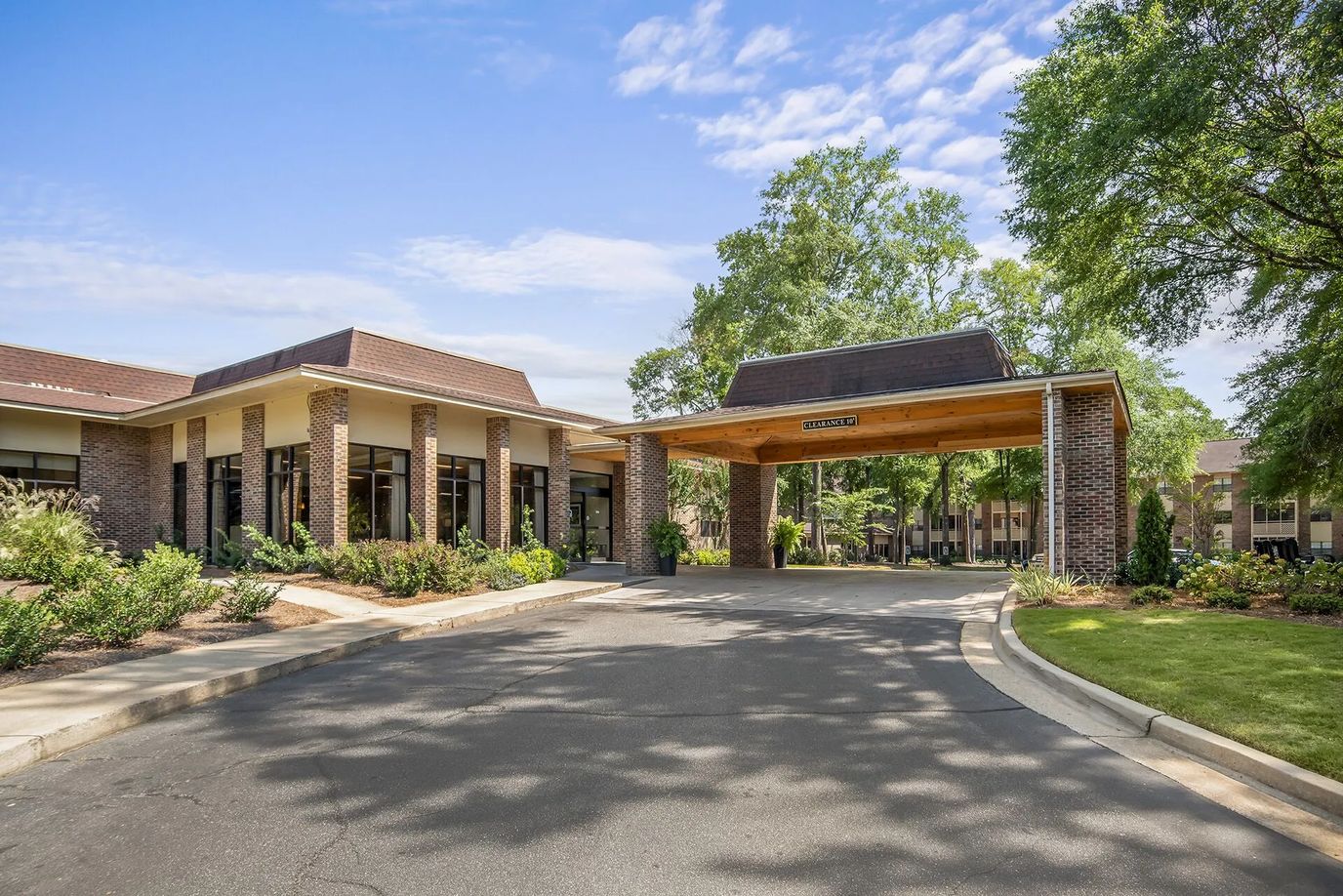 Front entrance of a senior living facility surrounded by greenery