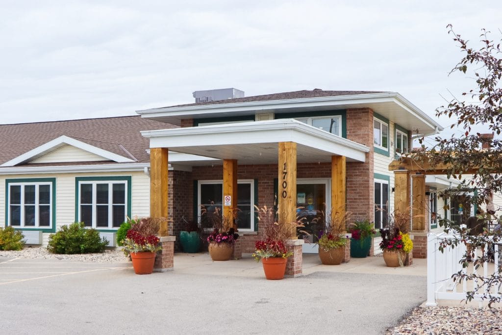Front entrance of a senior living facility with flower pots