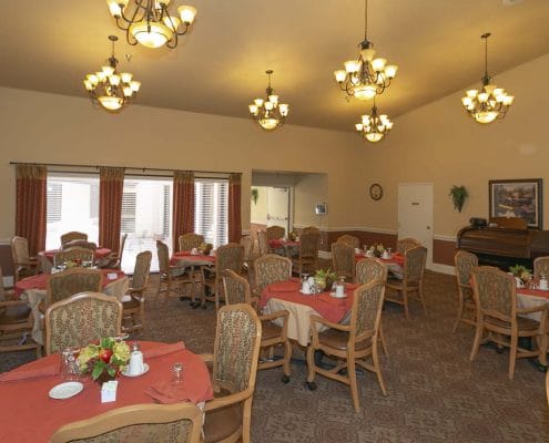 Dining area with tables and chairs in a care facility.