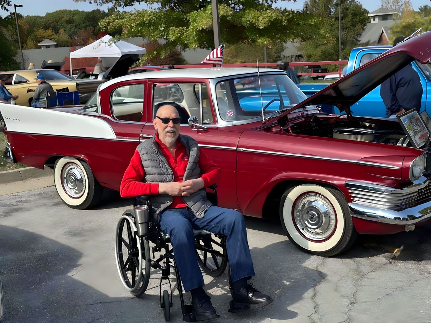 A resident enjoying a classic car show in a wheelchair