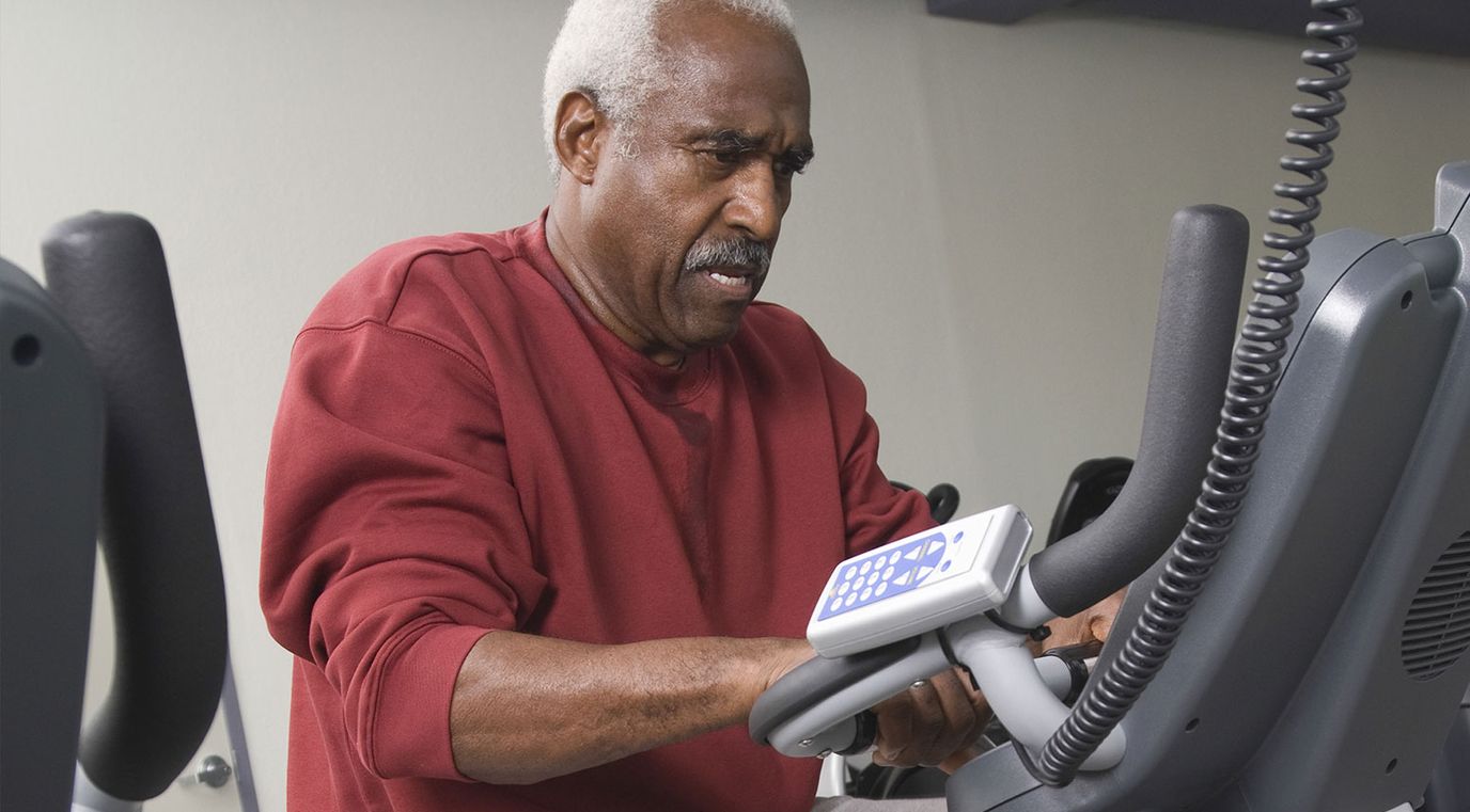A senior resident exercising on an elliptical machine