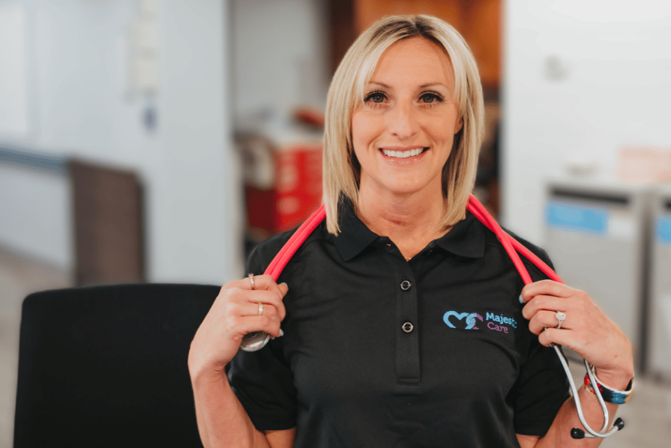 Majestic Care of Terre Haute, Nursing Home in Terre Haute, IN — Smiling staff member wearing a Majestic Care shirt