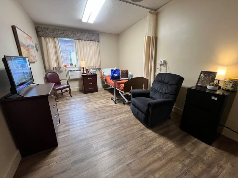 Cozy private resident room with a bed and chair