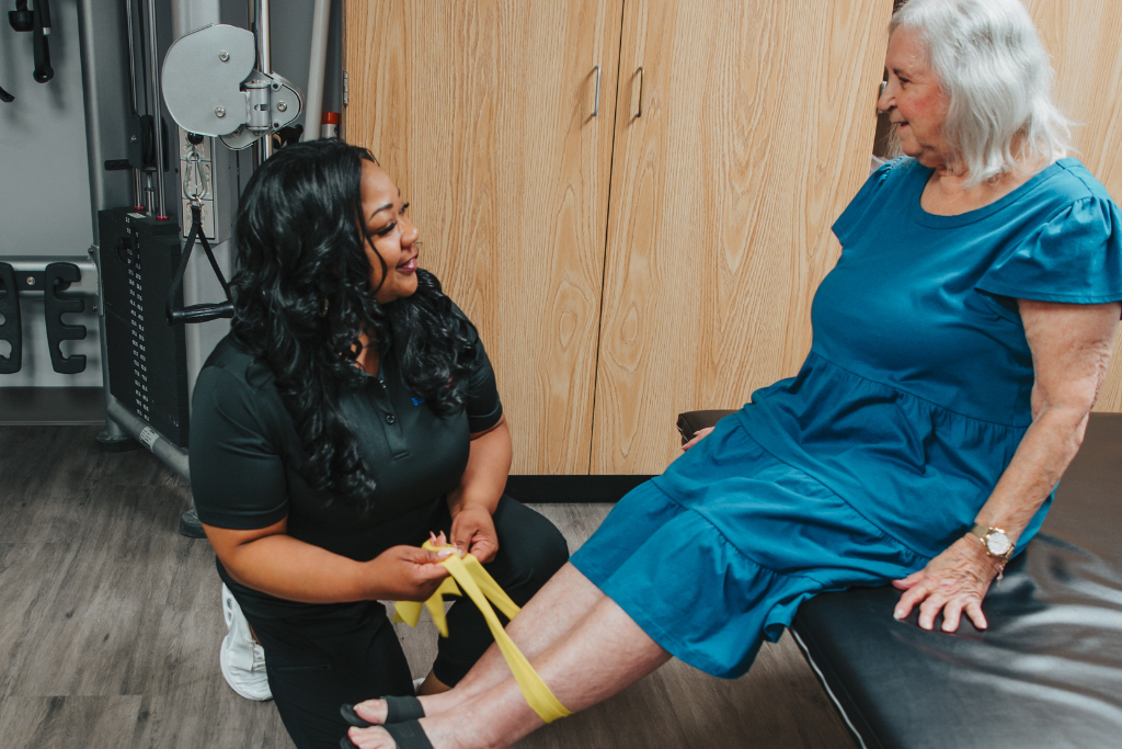 A staff member assisting a resident with therapy exercises