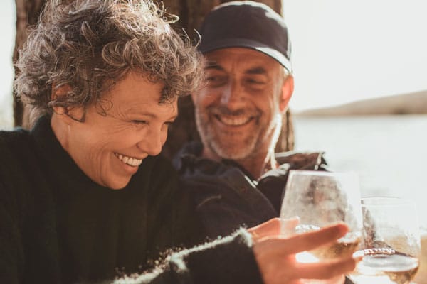 Two smiling residents enjoying drinks together outdoors.