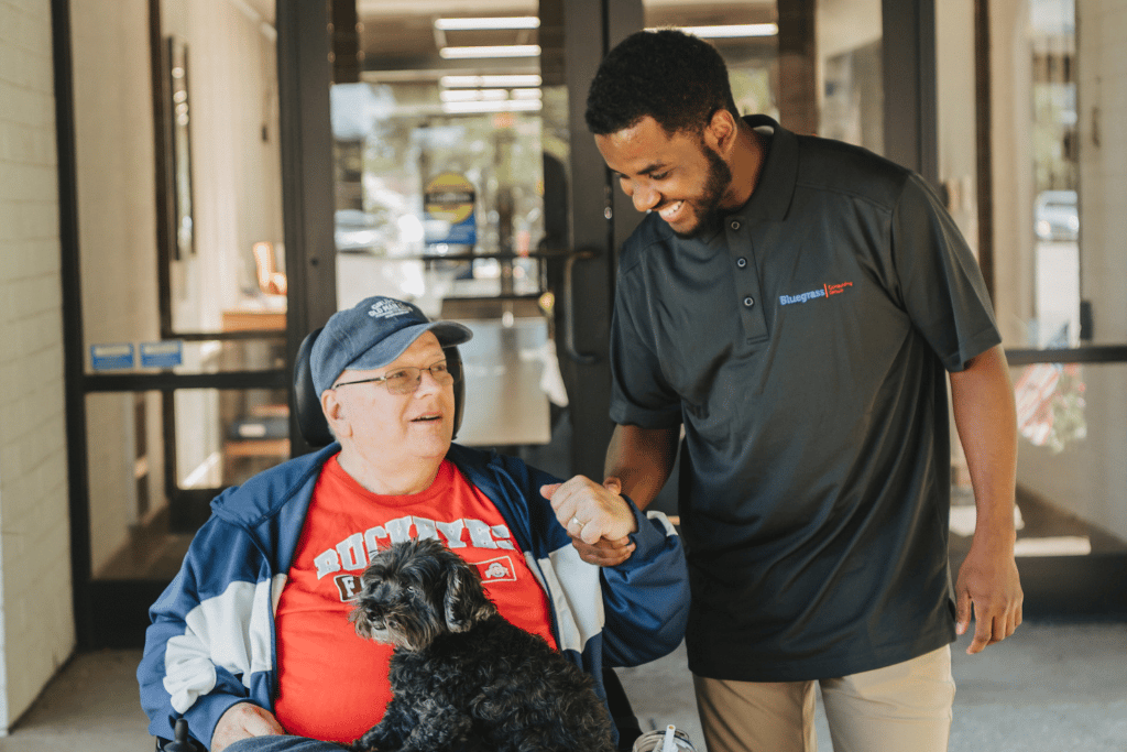 A resident and staff member smiling outside the facility