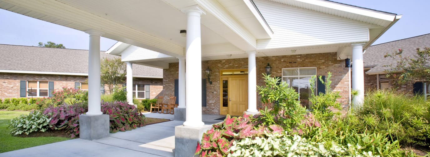 Front entrance of a senior living facility with gardens