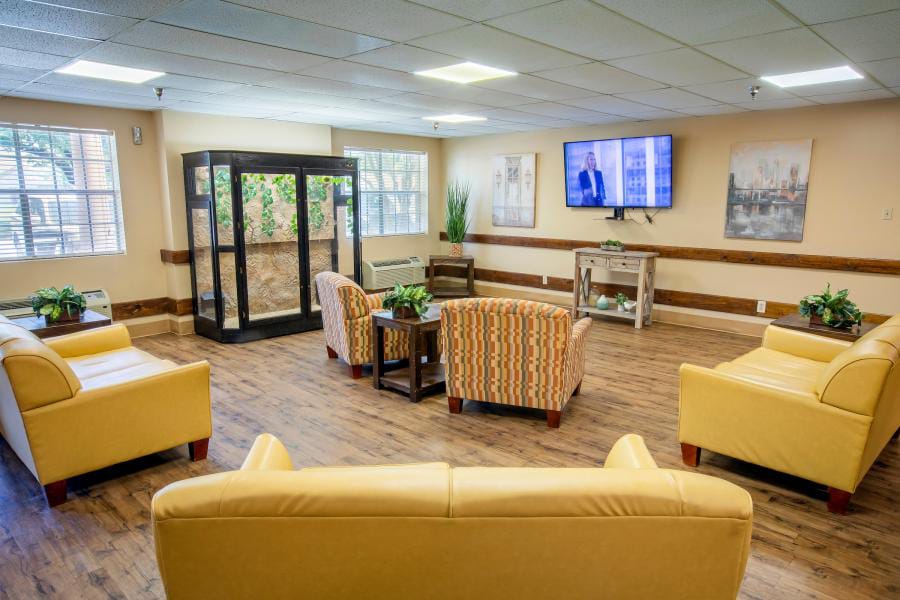 Bright common area with seating and a TV.