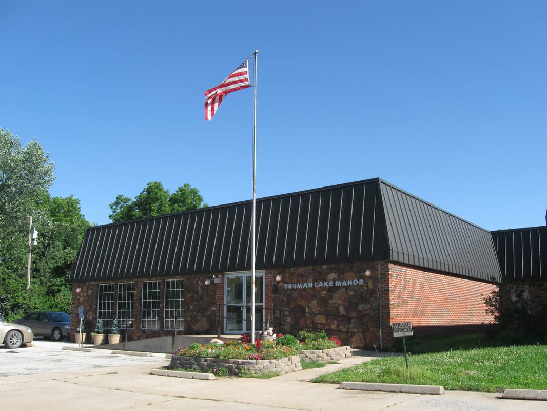 Exterior view of Truman Lake Manor with flag