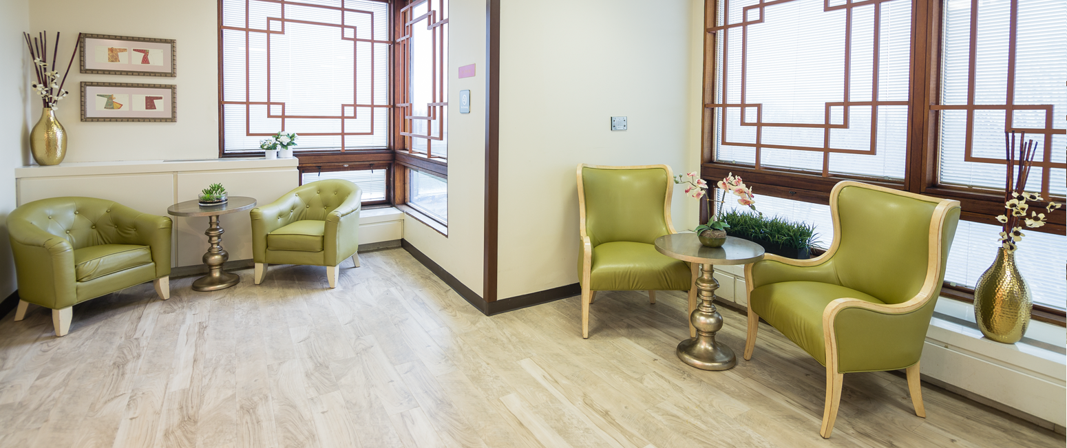 Bright common area with green chairs and tables