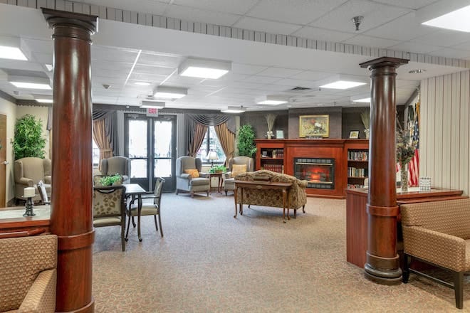 A cozy interior common area with seating and bookshelves