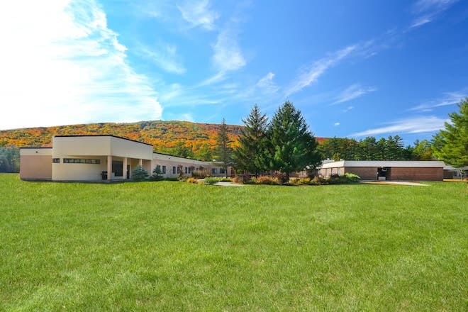 Exterior view of a senior living facility surrounded by grass