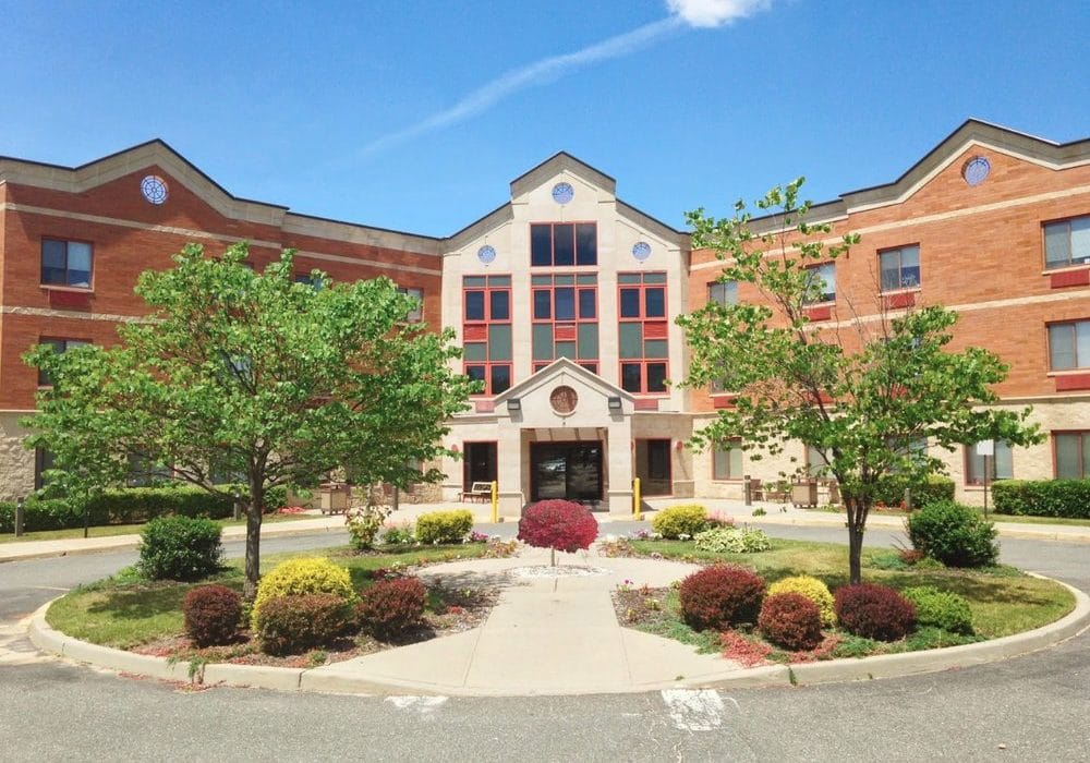 Front entrance of a senior living facility with landscaped gardens