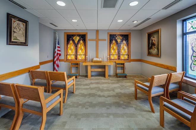 Quiet chapel space with wooden seating and stained glass windows