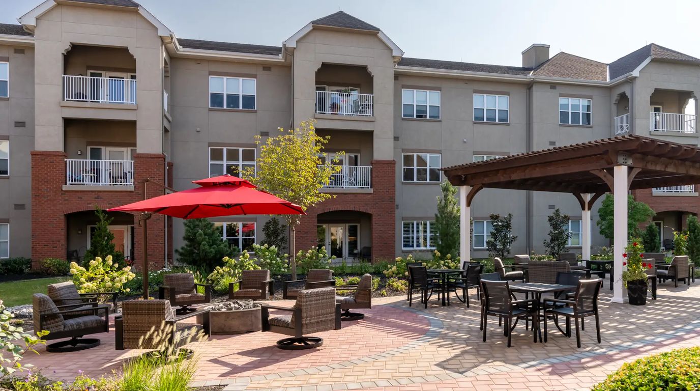 Outdoor seating area with red umbrellas and landscaping