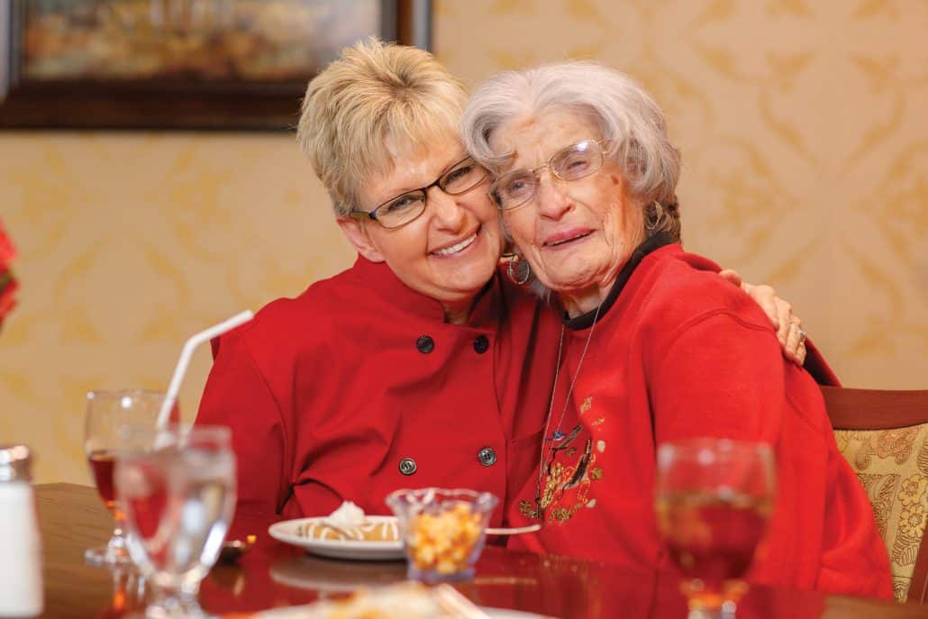 A resident and staff member enjoying a meal together