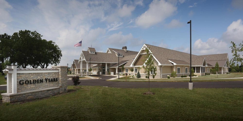 Golden Years of Lake Geneva, Nursing Home in Lake Geneva, WI — Senior living facility entrance with American flag and landscaping