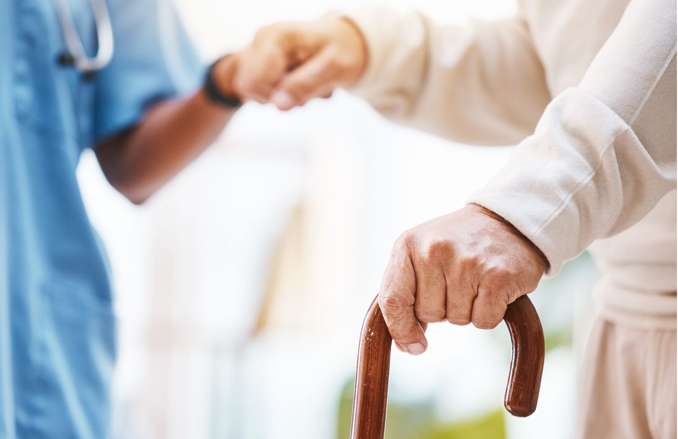 North Shore Healthcare at Marshfield, Nursing Home in Marshfield, WI — Elderly hand holding a cane with caregiver assistance