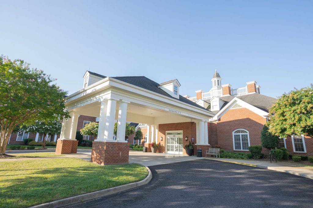 Entrance of a senior living facility with landscaped gardens