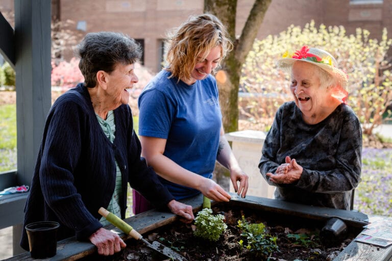 Residents and staff gardening in an outdoor space