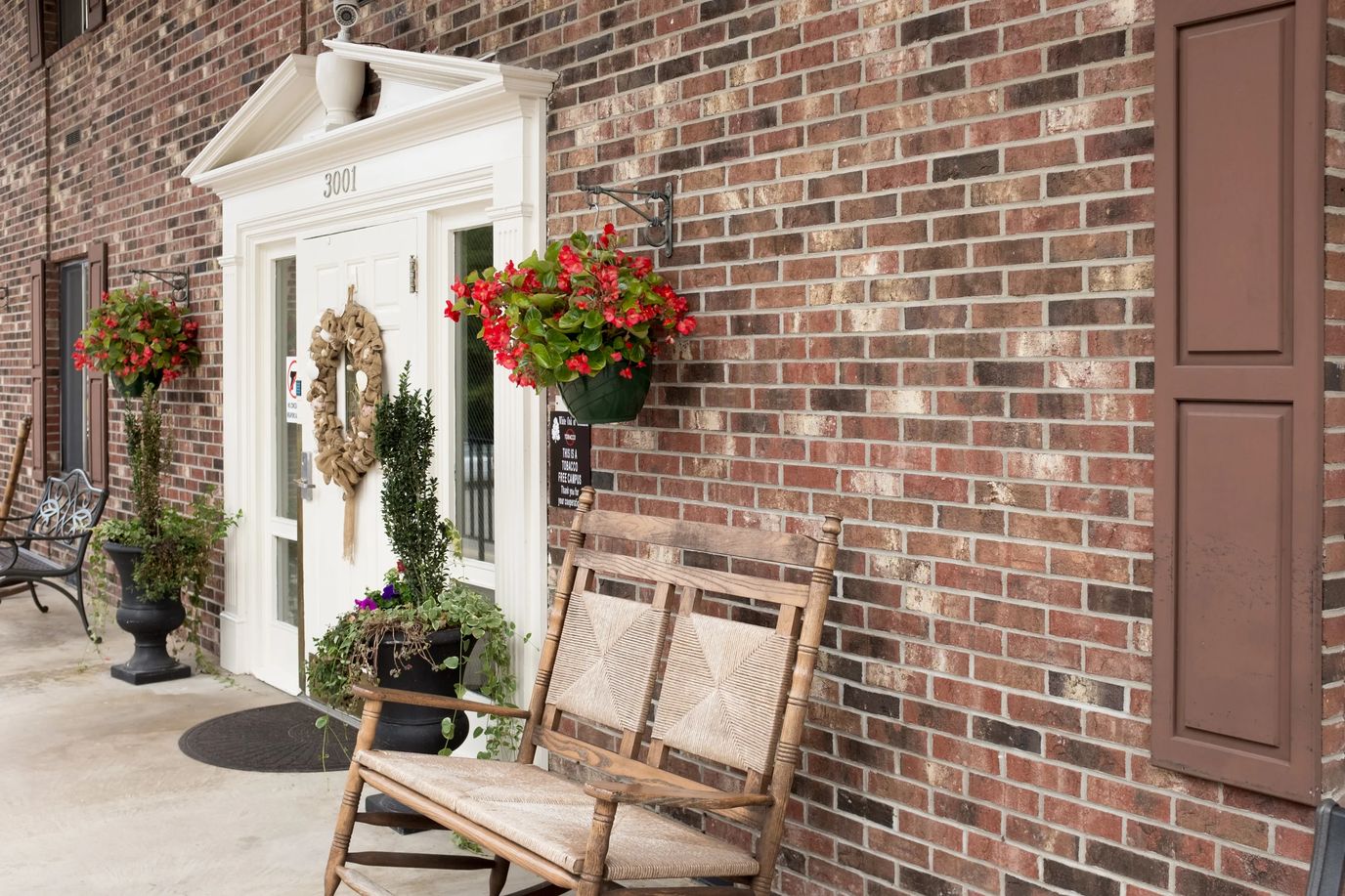 Welcoming entrance with flower baskets and seating