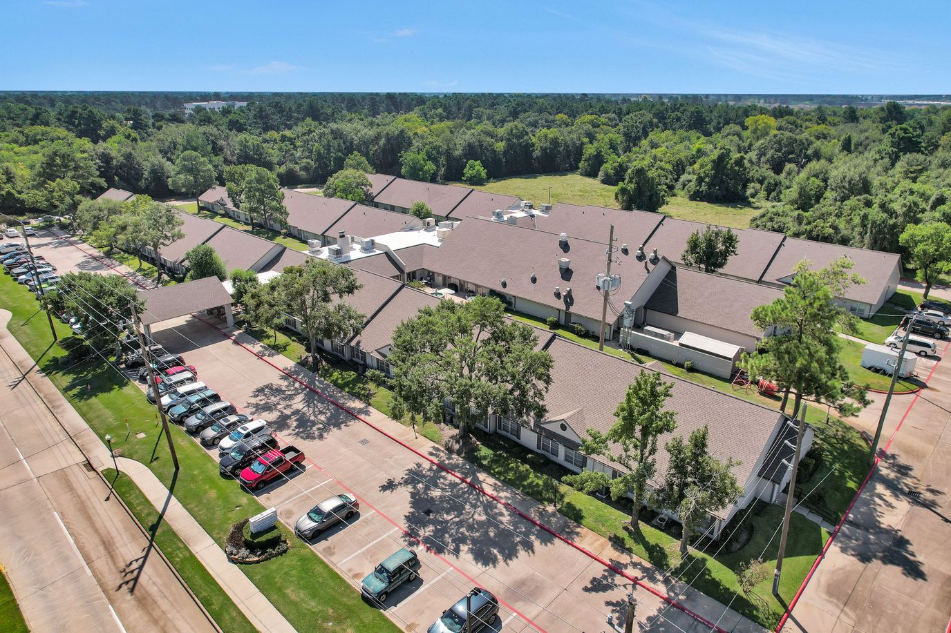Aerial view of a senior living facility with parking and green spaces