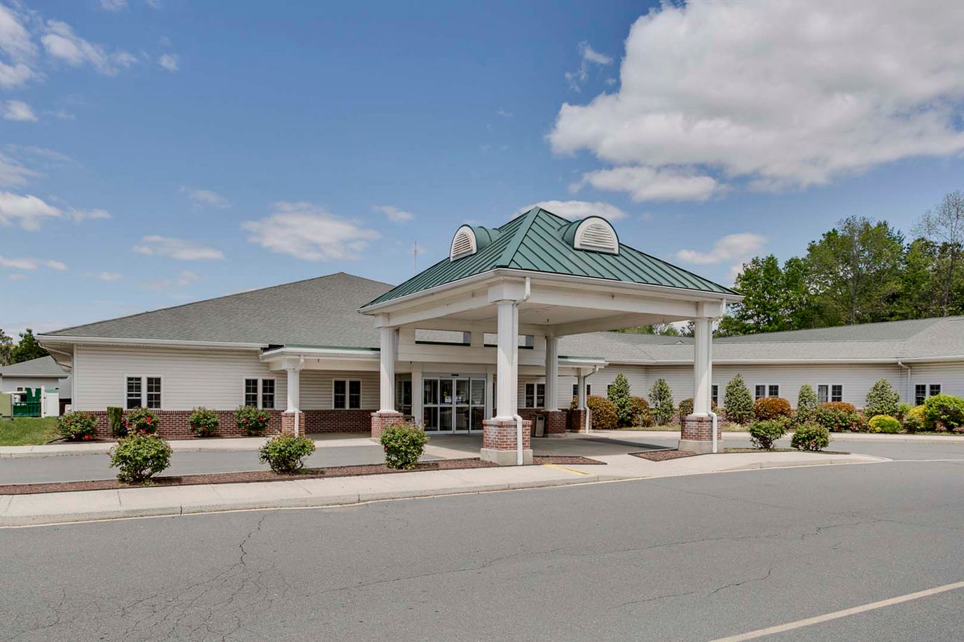 Front entrance of a senior living facility with landscaped grounds