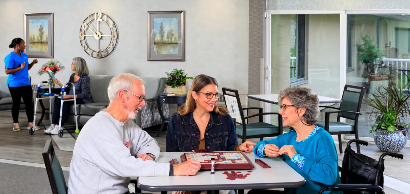 Residents engaging in a board game in a common area.