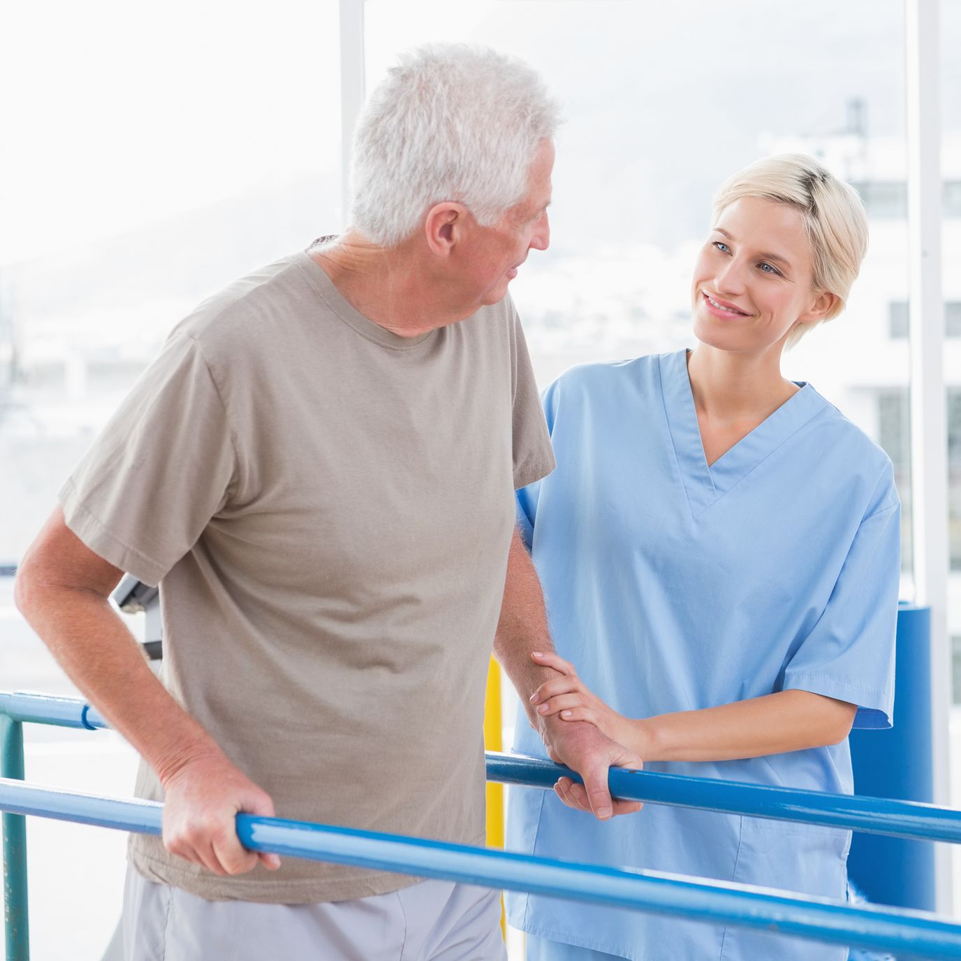 A caregiver assisting a senior man in therapy