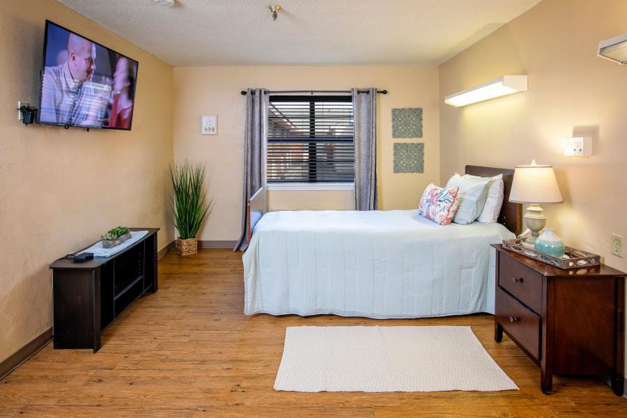 Cozy resident room with bed, TV, and seating area