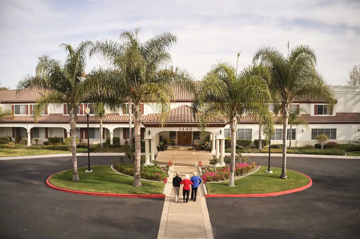 Residents walking towards the entrance of an assisted living facility