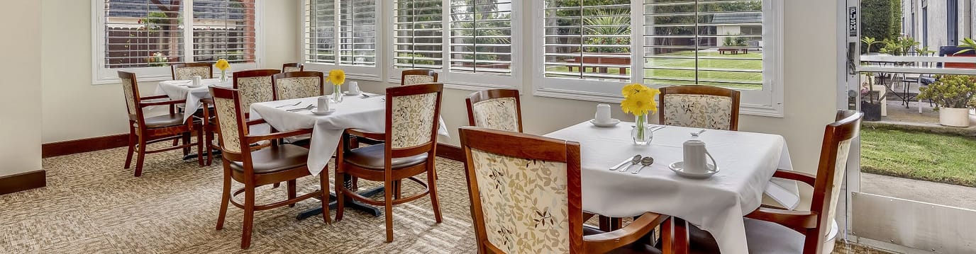 Dining area with tables and flowers in sunlight